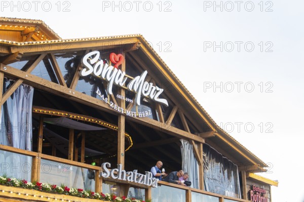 Balcony view of a Bavarian wooden building with festive decoration, Cannstatter Wasen folk