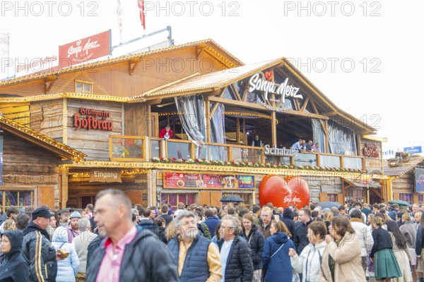Large crowd in front of a Bavarian festival hall with a warm atmosphere, Cannstatter Wasen folk