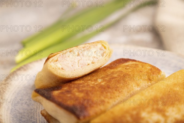 Fried crispy pancakes with meat and cheese on brown concrete background and linen textile. side