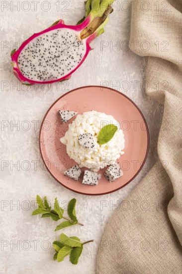 White ?ottage cheese, Curd, with Pithaya on gray concrete background and linen textile, top view,