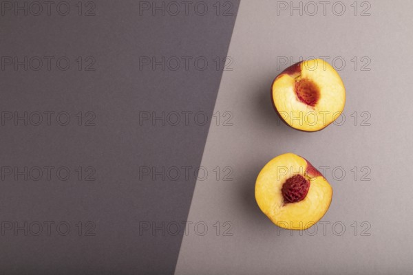 Peach Cut in half on black and gray paper pastel background. Top view, flat lay, copy space.