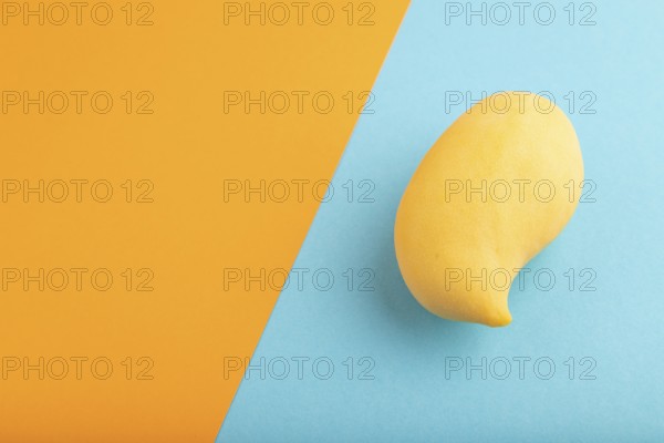 Orange mango on orange and blue paper pastel background. Side view, copy space. healthy food,