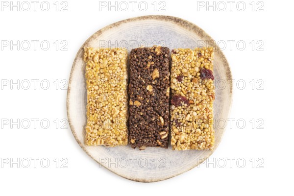 Granola bars with caramel, nuts, flakes in ceramic plate isolated on white background. Top view,