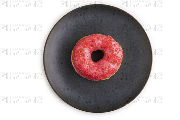 Pink Donut with sprinkles on blue ceramic plate isolated on white background, top view, flat lay,