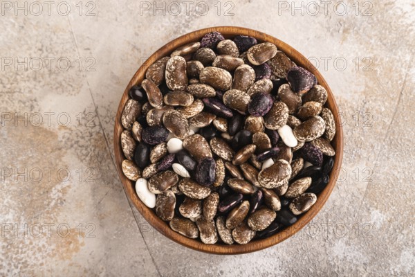 Wooden bowl with Kidney beans on brown concrete background, top view, flat lay, copy space,