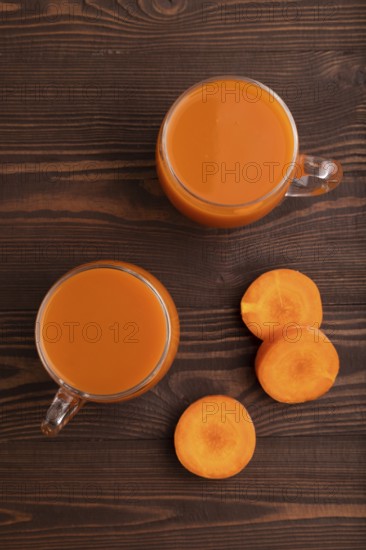 Two glasses with carrot juice, on wooden background. Diet, healthy eating concept. top view, flat