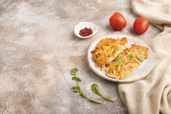 Baked chicken meat with cheese and tomatoes on brown concrete background and linen textile. side