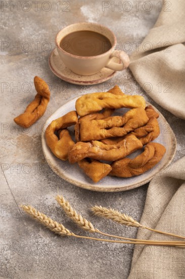 Crunchy biscuit Brushwood cookies sprinkled with powdered sugar on brown concrete background and