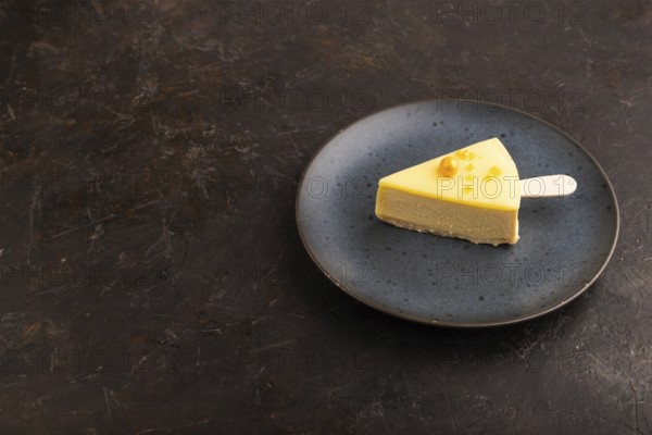 Yellow Cake pop with sprinkles on blue ceramic plate on black concrete background, side view, copy
