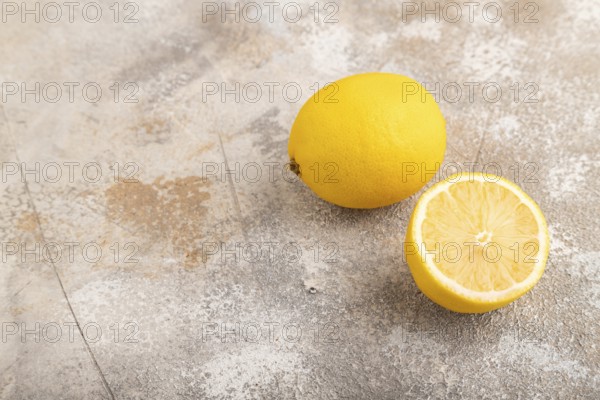 Yellow Lemon Cut in half on brown concrete background. Side view, copy space. healthy food,