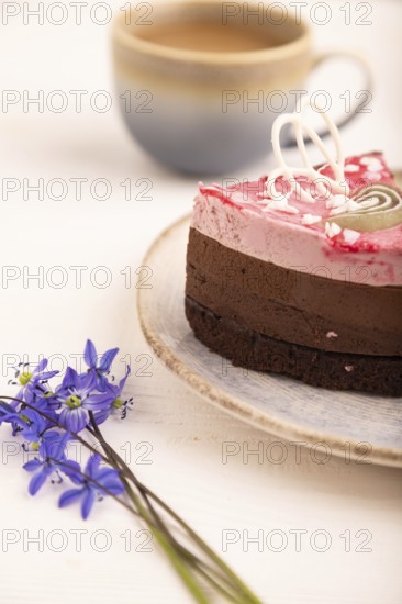 Chocolate cake on white wooden background and orange linen textile, cup of coffee, side view, close