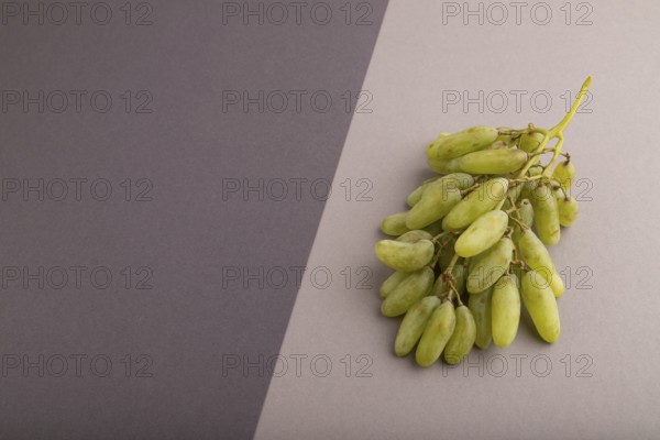 Green grapes on gray and black paper pastel background. Side view, copy space. healthy food,