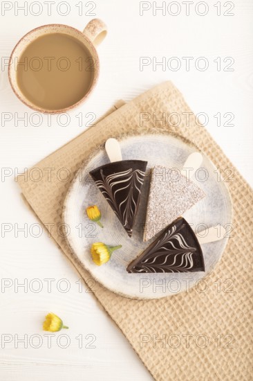 Chocolate and Vanilla Cake pops Marshmallow with cup of coffee on white wooden background and beige