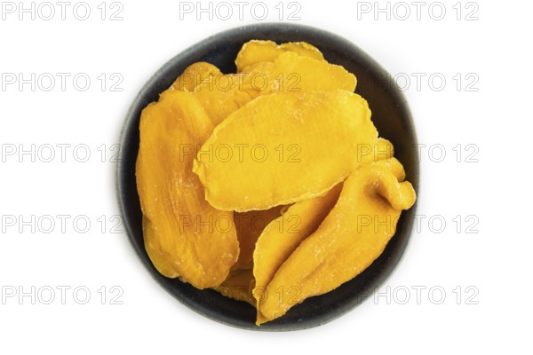 Dried Mango in blue ceramic bowl isolated on white background. Top view, close up, flat lay.