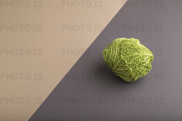 Green lettuce on beige and gray pastel paper background. Side view, copy space, flat lay. healthy