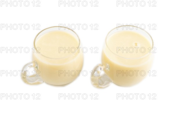 Organic non dairy banana and soy milk in glass cup on brown wooden background. Vegan healthy food