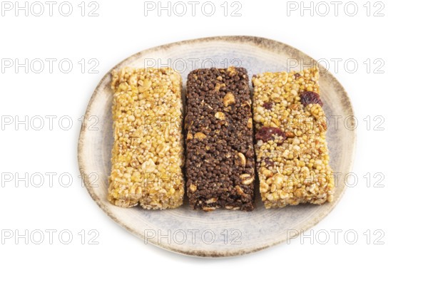 Granola bars with caramel, nuts, flakes in ceramic plate isolated on white background. Side view,