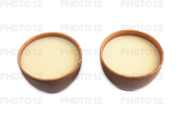 Organic non dairy banana and soy milk in clay cup isolated on white background. Vegan healthy food