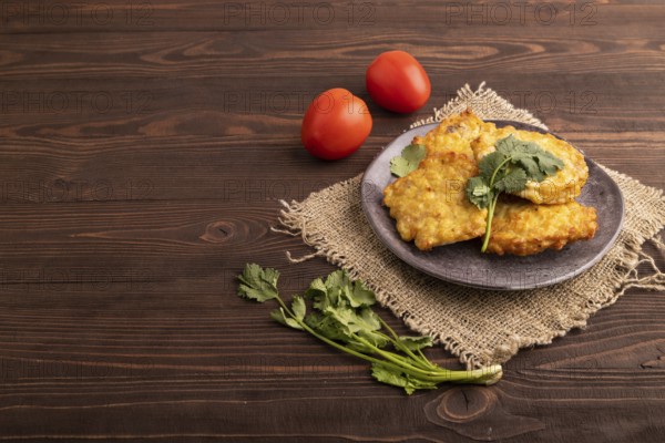 Fried crispy Chicken pancakes on brown wooden background and linen textile. side view, copy space