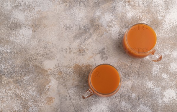 Two glasses with carrot juice, on brown concrete background. Diet, healthy eating concept. top