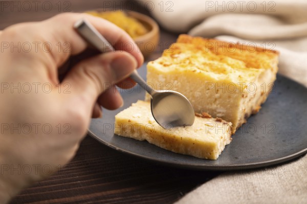?ottage cheese ?asserole, Curd cake, with dried apricots and raisins with hand on brown wooden