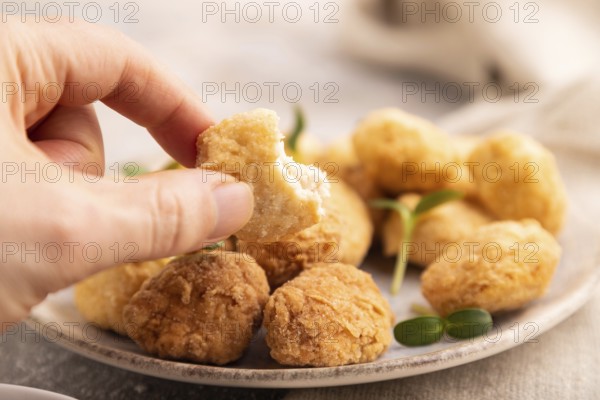Fried crispy Chicken Nuggets with ketchup, microgreen on brown concrete background and linen