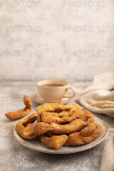 Crunchy biscuit Brushwood cookies sprinkled with powdered sugar on brown concrete background and