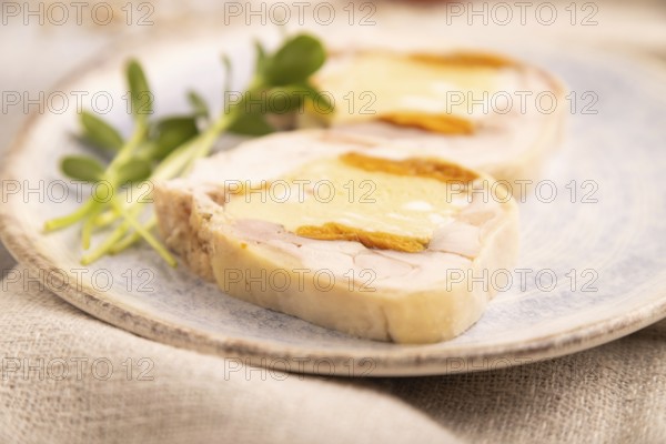 Chicken, egg and dried apricot meatloaf, microgreen on brown concrete background and linen textile.