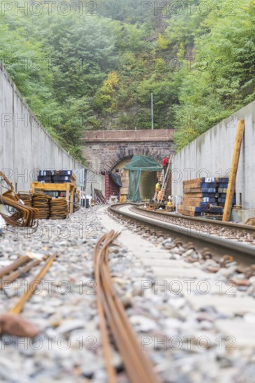 Eisenbahnbaustelle mit sichtbarem Tunnel und gestapeltem Material, Bau der Hermann Hessenahn, Calw,