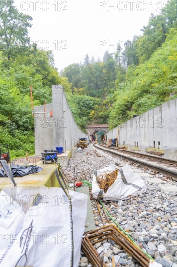 Bauarbeiten an einer Bahnstrecke mitten im Wald mit Betonmauern und Schienen, Bau der Hermann