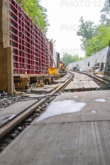 Baustelle entlang einer Schienenstrecke mit Holzarbeiten und Arbeitern, Bau der Hermann Hessenahn,