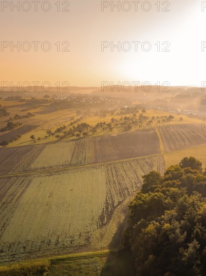 Luftaufnahme einer ländlichen Landschaft bei Sonnenaufgang und leichtem Nebel, Gechingen,