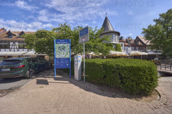 Platz, Parkplatz, Auto, Fachwerkhäuser, Turm, Bäume, Hecke, blauer Himmel, Cumuluswolken,