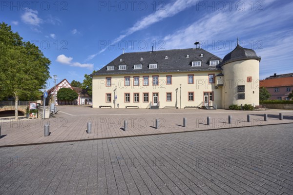 Kellereigebäude Hofheim, Bürgersteig, Absperrpoller, Bäume, Laterne, blauer Himmel, Cumuluswolken,