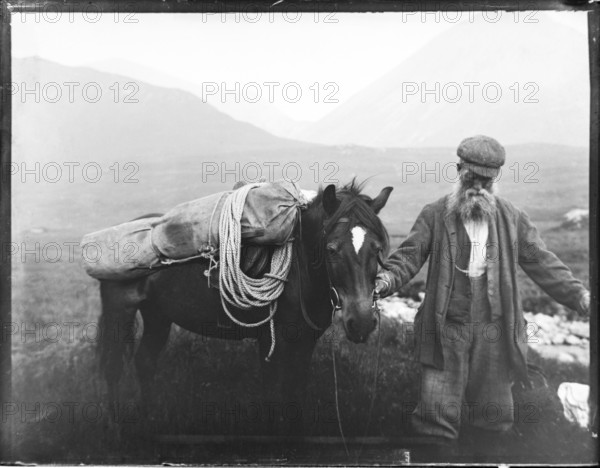 Old man with pack horse carrying mountaineering equipment, thought to be Cuillin mountains, Skye,
