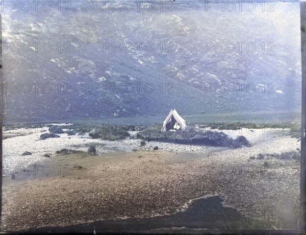 Tent camp on island in river of mountain valley, thought to be Cuillin mountains, Skye, Scotland,