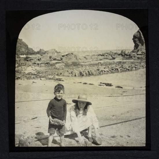 Magic lantern slide two children playing on a sandy beach circa 1900 location not known, presumed