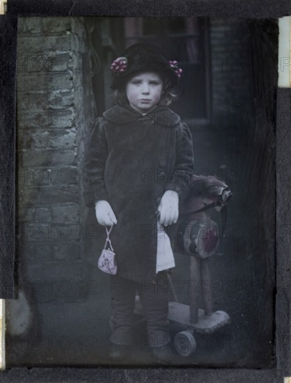 Paget process colourised magic lantern slide portrait of a young girl dressed up in adult clothing,