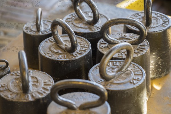 Close-up of old metal weights used in traditional cheese scales, former city scales, cheese market,