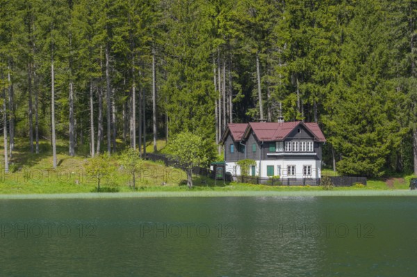 View over Lake Toblach to a house standing directly on the shore, Toblach, Höhlensteintal, South