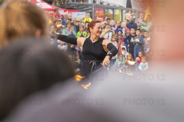 Energetic demonstration with fire wheels in front of an excited audience and curious children,