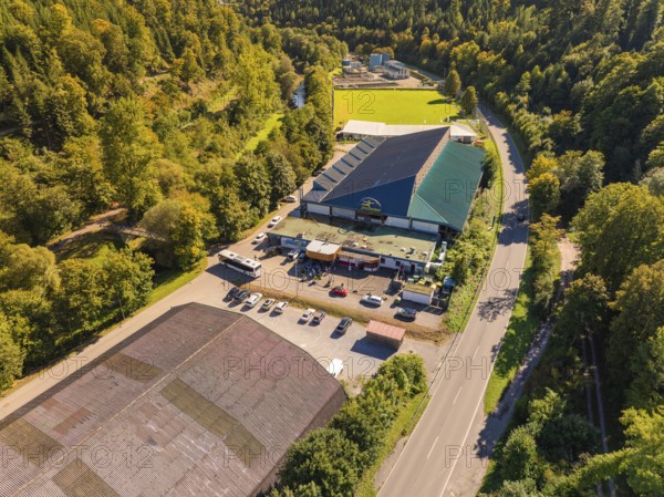 Industrial building complex near a road in the countryside, large car park, sunny atmosphere,