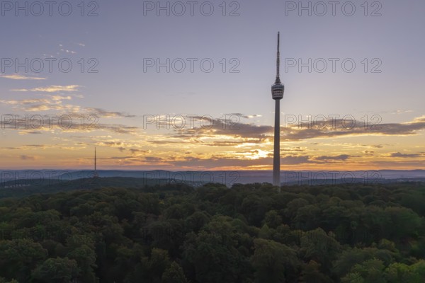 Sunrise behind a television tower in the forest with clouds in the sky, Stuttgart-Degerloch,