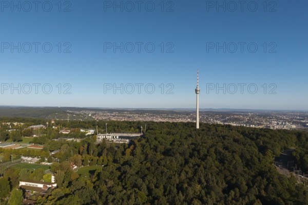 Impressive view over a green forest landscape with a striking television tower and a city in the