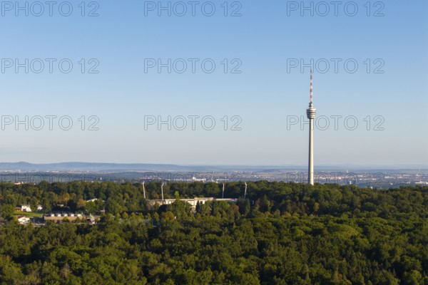 Stuttgart television tower rises above a forest with an urban backdrop on the horizon, Gazi