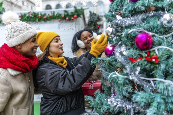 Happy multi ethnic friends gathering at an outdoor christmas market, joyfully decorating a colorful