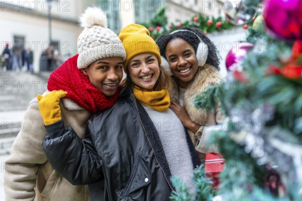 Happy multi ethnic friends enjoying christmas city during winter holidays, wearing winter clothes