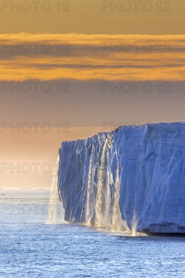Waterfall at edge of Brasvellbreen glacier from the ice cap Austfonna pouring into the Barents Sea