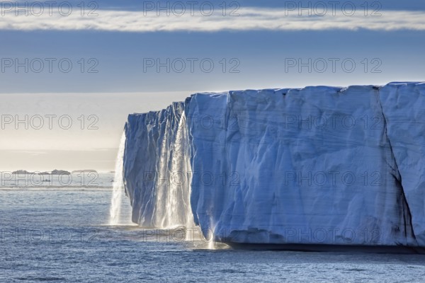 Waterfall at edge of Brasvellbreen glacier from the ice cap Austfonna pouring fresh water into the