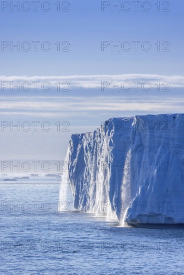 Waterfall at edge of Brasvellbreen glacier from the ice cap Austfonna pouring fresh water into the